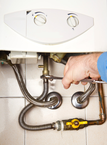 Plumber at work fixing gas boiler