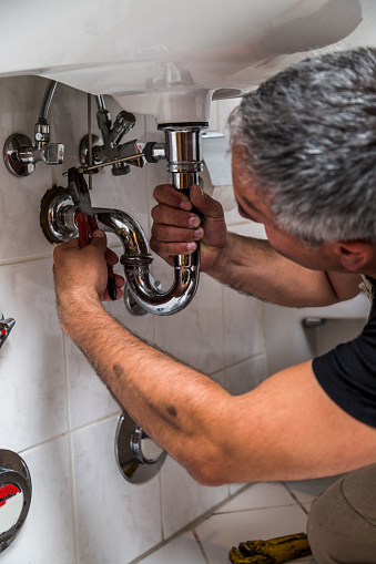 A plumber fixing the bathroom sink